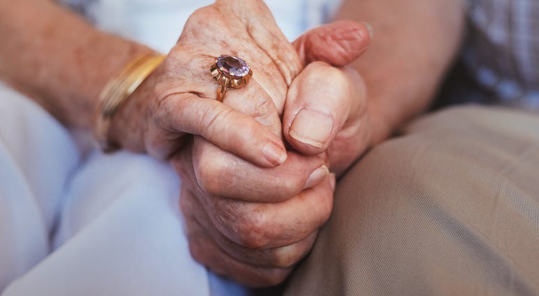 Elderly couple holding hands.