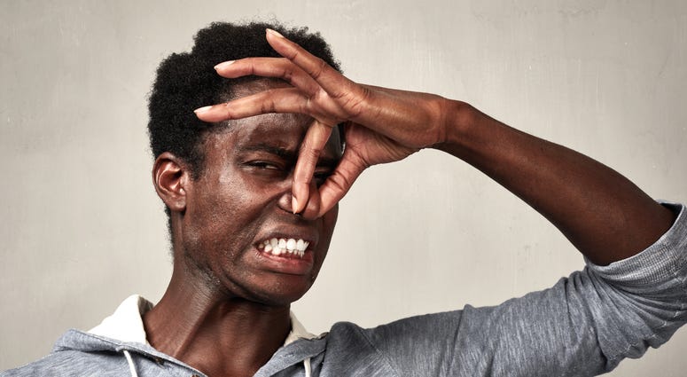Man holds nose because something smells terrible