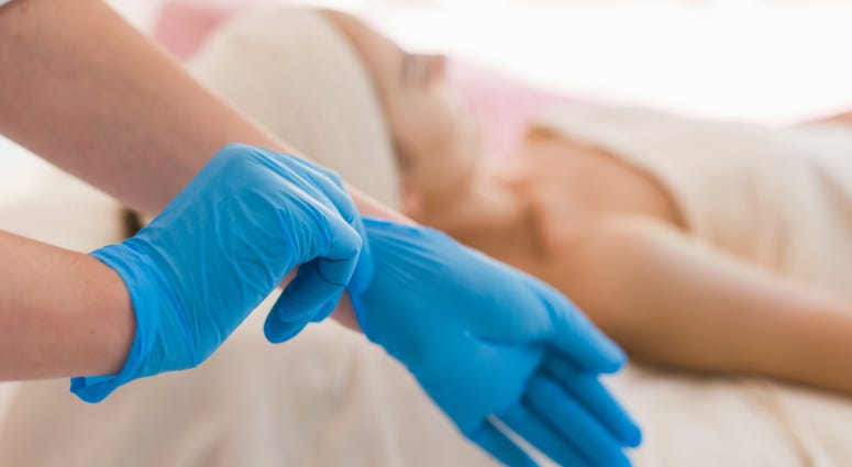 Facialist puts on gloves