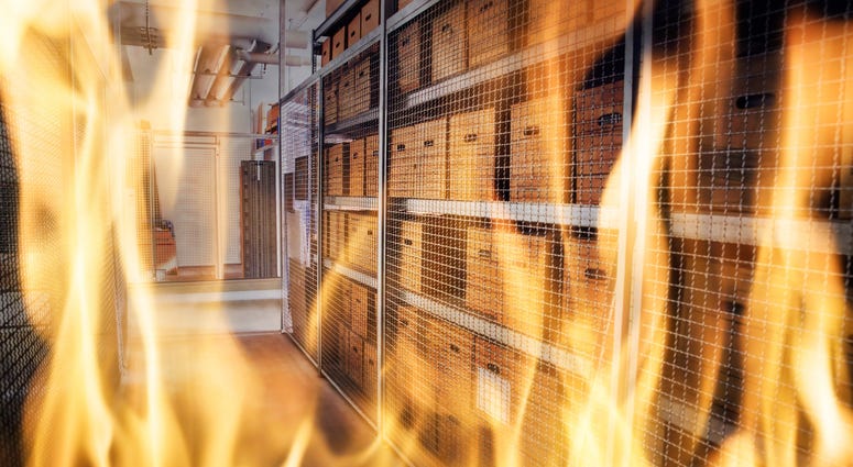 Flames showing with shelves full of boxes in the background