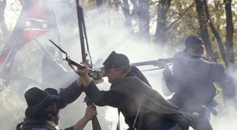 Civil War reenactors fighting with rifles and bayonets.