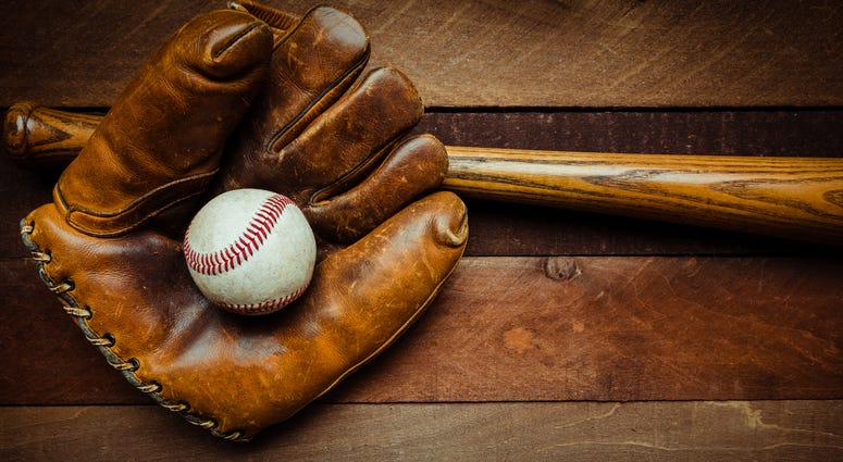 A group of vintage baseball equipment, bats, gloves, baseballs on wooden background A group of vintage baseball equipment, bats, gloves, baseballs on wooden background