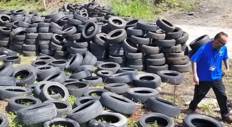 Kansas City illegal dumping investigator walks through a lot containing thousands of tires
