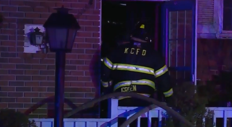 Firefighters investigate the scene of a house fire where a firefighter was hurt.