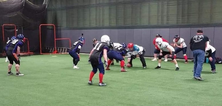 Female football players in full uniform line up for a practice play