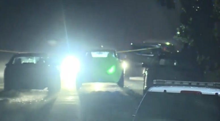 Crime scene tape and police vehicles on residential street at night