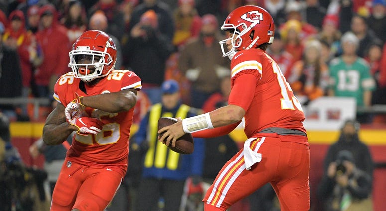 Dec 13, 2018; Kansas City, MO, USA; Kansas City Chiefs quarterback Patrick Mahomes (15) fakes a handoff to running back Damien Williams (26) during the game against the Los Angeles Chargers at Arrowhead Stadium. The Chargers won 29-28. Mandatory Credit: D