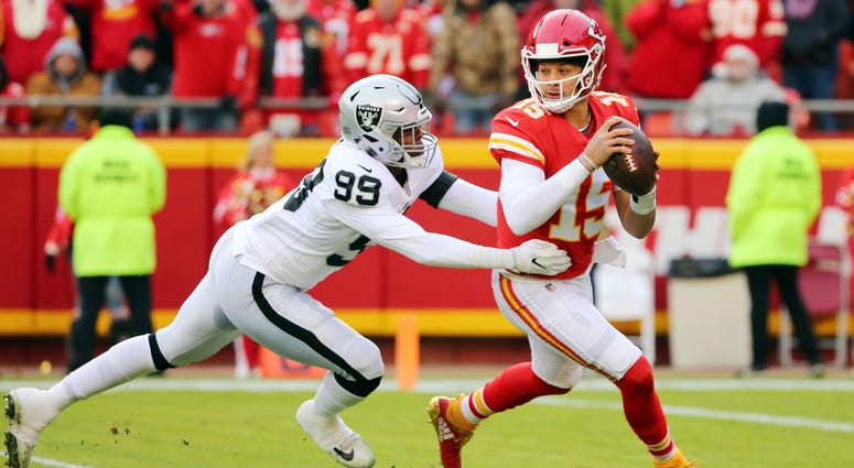 Dec 30, 2018; Kansas City, MO, USA; Kansas City Chiefs quarterback Patrick Mahomes (15) scrambles from Oakland Raiders defensive end Arden Key (99) in the first half at Arrowhead Stadium. Mandatory Credit: Jay Biggerstaff-USA TODAY Sports