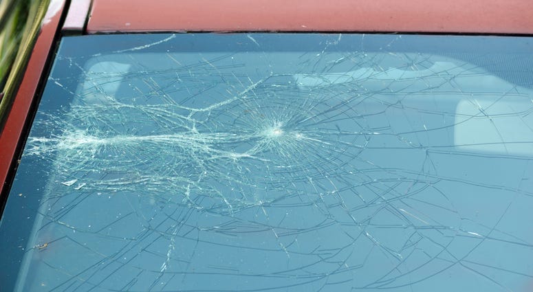 Broken and damaged front red car windshield shattered glass window