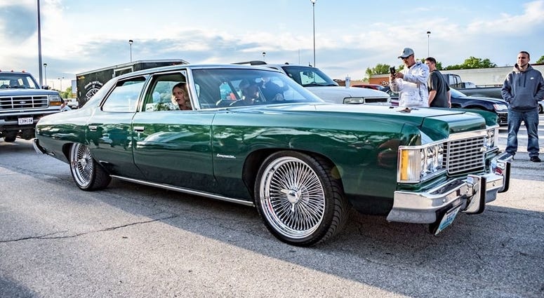 People ride in a classic car during a cruise on Noland Road in Independence, MO