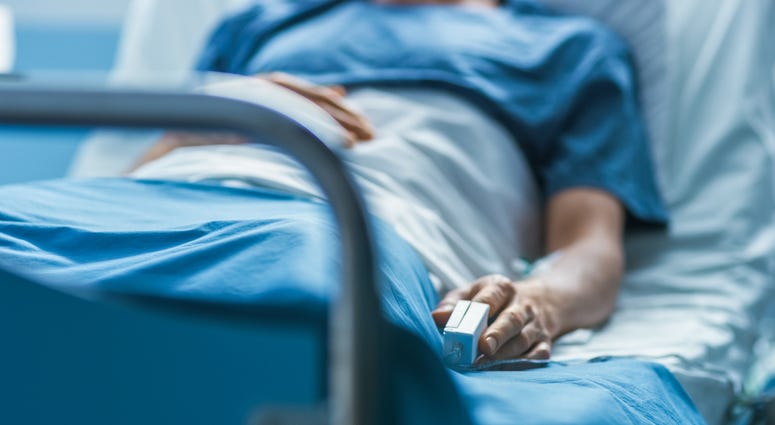 A man lies in a hospital bed