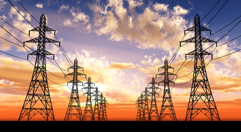 Power lines fade off into a setting sun