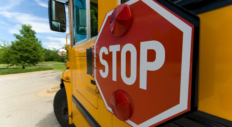 A school bus with a focus on its swing-out stop sign