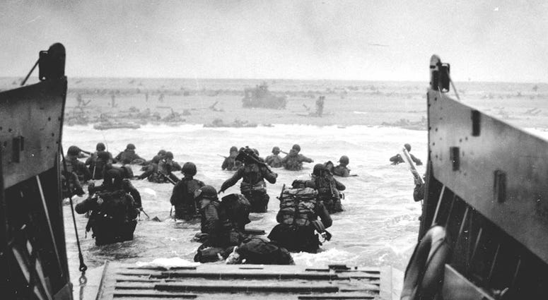 U.S. Soldiers disembark a landing craft at Normandy, France, June 6, 1944. By the end of the day some 150,000 Allied troops had landed on five Normandy beaches and three airborne drop zones. The invasion marked the beginning of the final phase of World Wa