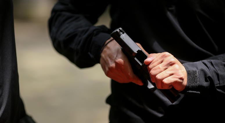 Man operates slide on a semi-automatic handgun