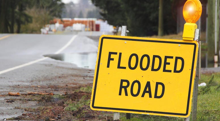 Flooded road sign warns drivers.