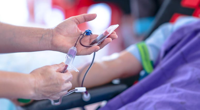 A nurse assists with a blood donation