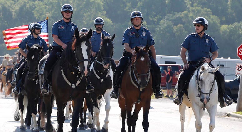 Mounted patrol officers ride their horses.