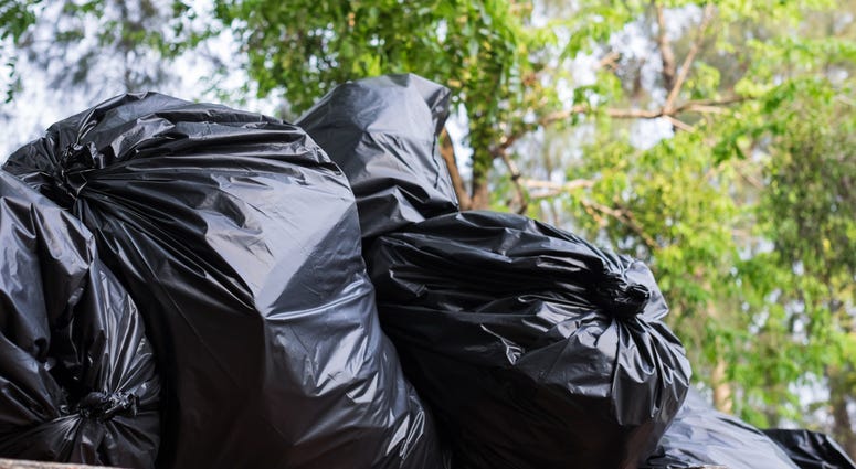 stacks of filled black trash bags