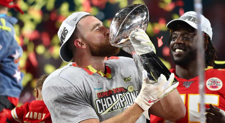 Kansas City Chiefs tight end Travis Kelce (87) kisses the Lombardi Trophy as he celebrates after defeating the San Francisco 49ers in Super Bowl LIV at Hard Rock Stadium
