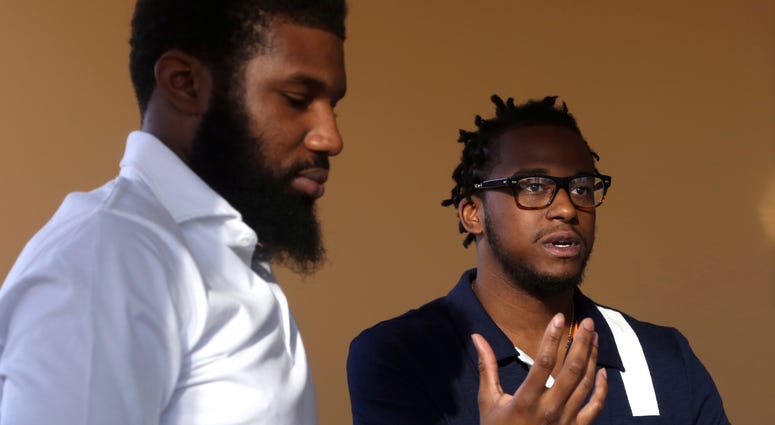 In this Wednesday, April 18, 2018 photo, Rashon Nelson, left, listens as and Donte Robinson, right, addresses a reporter's question during an interview with The Associated Press in Philadelphia. Their arrests at a local Starbucks quickly became a viral vi