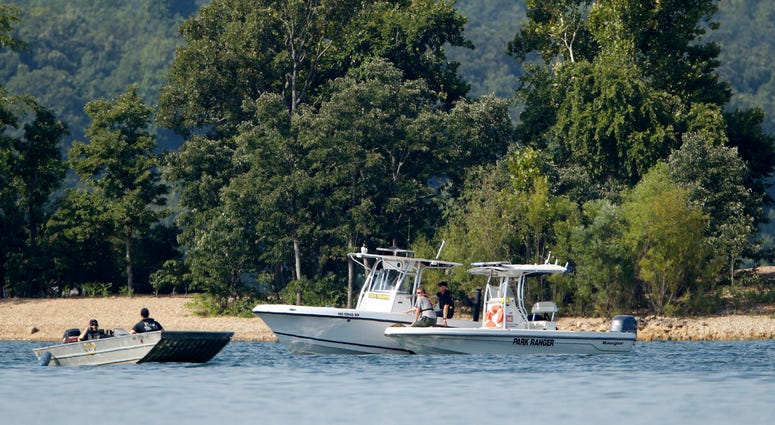 Emergency workers patrol an area Friday, July 20, 2018, near where a duck boat capsized the night before resulting in at least 13 deaths on Table Rock Lake in Branson, Mo.