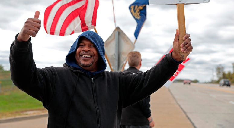 Bill Jackson, of St. Louis, gives a thumbs up to drivers that wave or honk as United Auto Workers outside the GM Wentzville Assembly Center in Wentzville, Mo., Wednesday, Oct. 16, 2019.