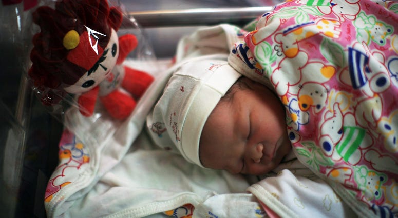 Olympics Opening Day BEIJING - AUGUST 08: A Chinese baby sleeps next to a Beijing Olympic Mascot Fuwa at the Beijing Haidian maternal and child healthcare hospital after being born on August 8, 2008 in Beijing, China. There were 50 babies born at the hospital, about 60 percen