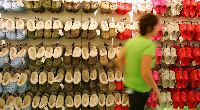 A shop assistant passes rows of hanging Crocs in the first UK Crocs store on October 18, 2007 in London England.
