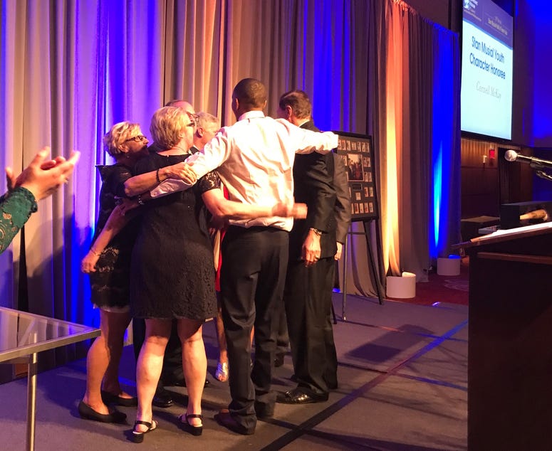 Cornell McKay hugging members of Stan Musial's family. Cornell McKay hugging members of Stan Musial's family.