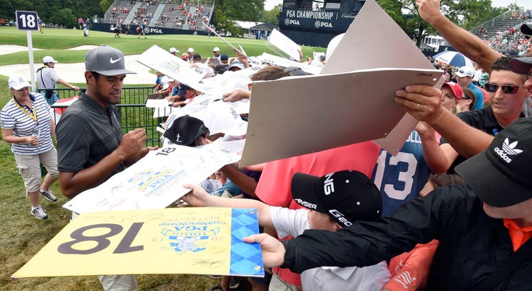 Tony Finau signs autographs for golf spectators off the 18th green. Tony Finau signs autographs for golf spectators off the 18th green.