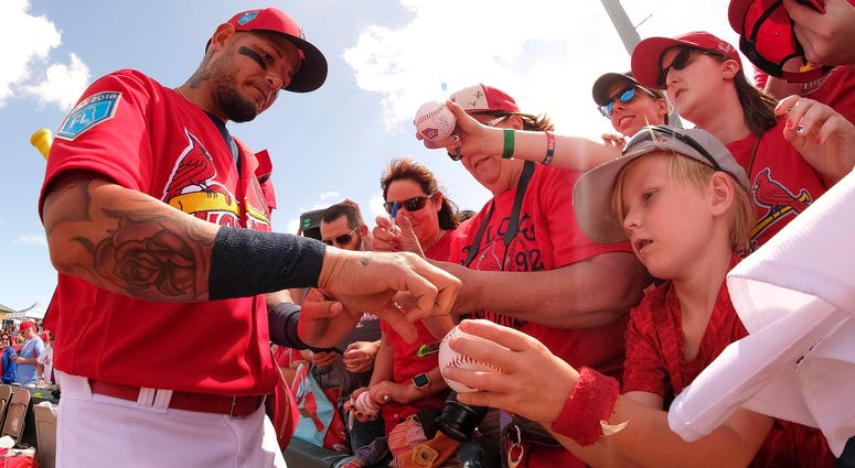 Yadier Molina sign autographs for fans at Roger Dean Stadium. Yadier Molina sign autographs for fans at Roger Dean Stadium.