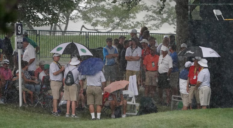 Fans look to seek shelter from the rain during a weather delay during the second round of the PGA Championship Fans look to seek shelter from the rain during a weather delay during the second round of the PGA Championship