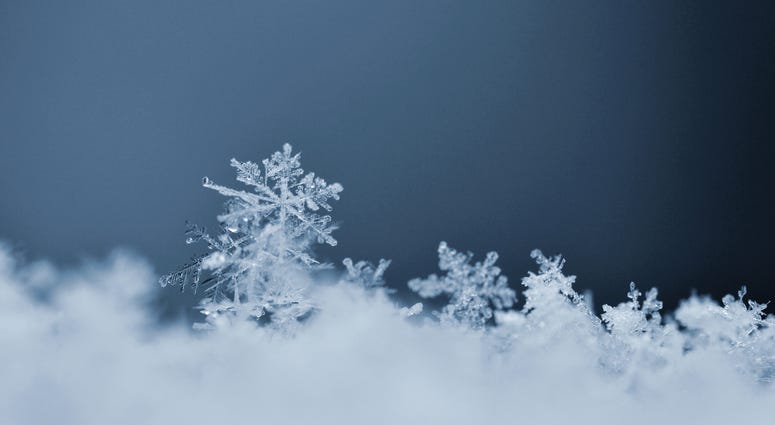 Snowflake. Macro photo of real snow crystal. Beautiful winter background seasonal nature and the weather in winter