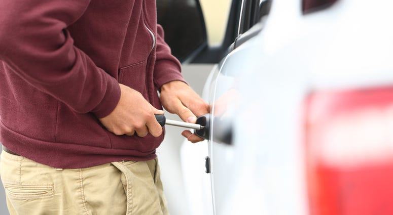 Stock image of someone breaking into a car. Stock image of someone breaking into a car.