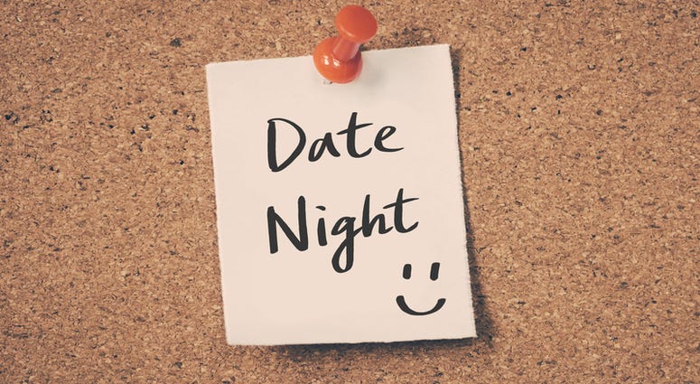 Date night reminder message on a cork board