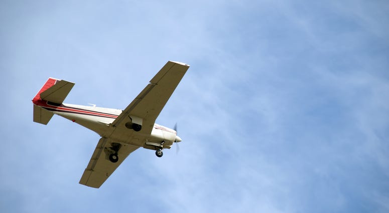 plane Small Plane with wheels out coming in for a landing.