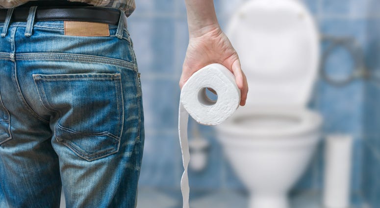 Stock image of a man holding toilet paper in the bathroom Stock image of a man holding toilet paper in the bathroom
