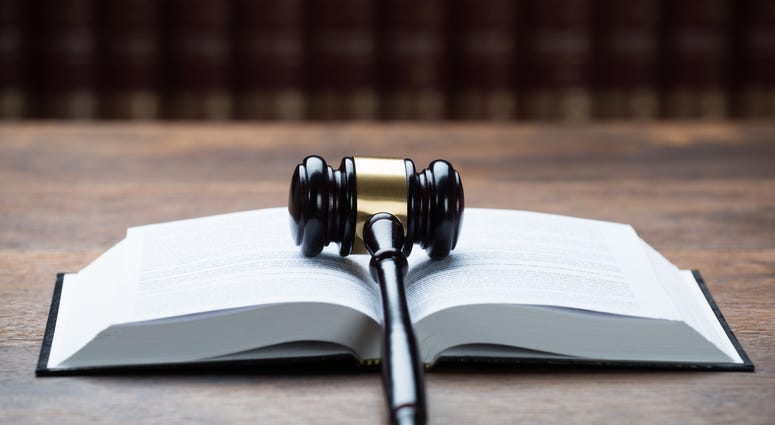 Closeup of mallet on open legal book at table in courtroom