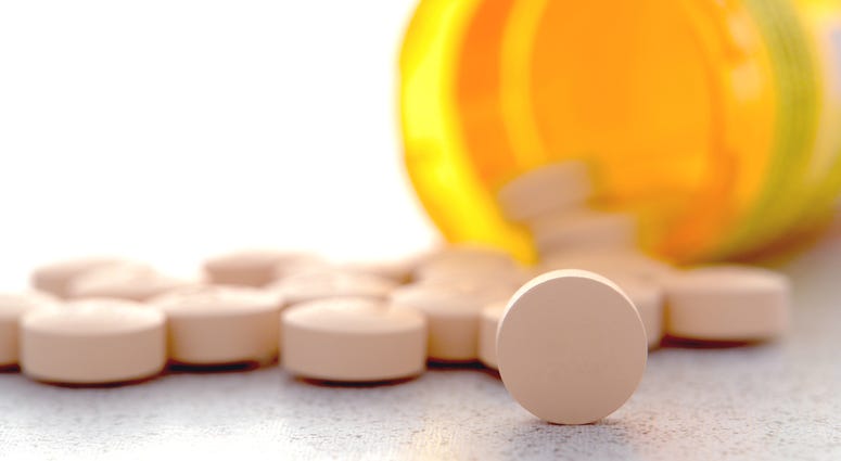 prescription drugs, pills Prescription pain RX medication pills spilled out of an amber pharmacy medicine bottle on a pharmacy counter