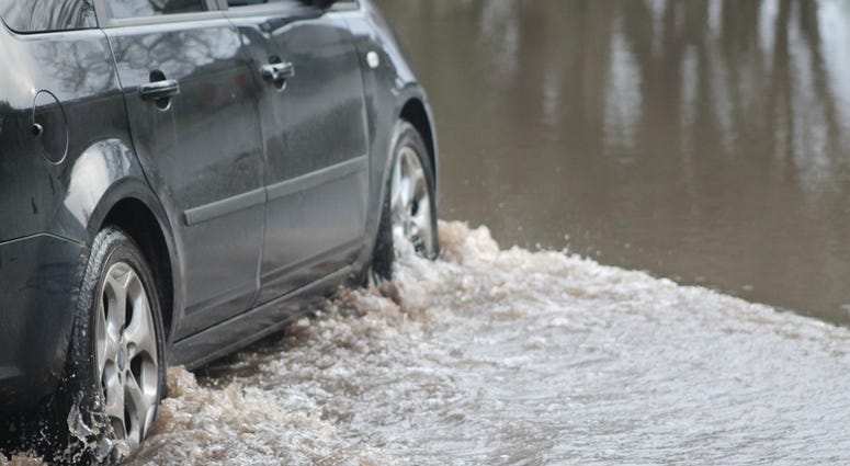 flood Car forcing a way through a flood on the River Ritec near Tenby, Pembrokeshire, UK