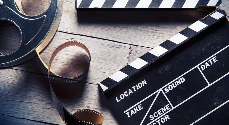 movie, film Movie clapper and film reel on a wooden background