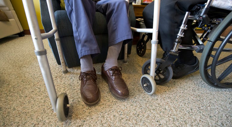 nursing home Concept for an elderly senior couple living in a nursing home or an assisted living facility. People growing old and aged is an ongoing issue. You can see a walker and a wheelchair.