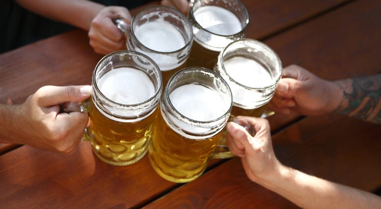 People in traditional costumes drinking beer in a Bavarian beer garden