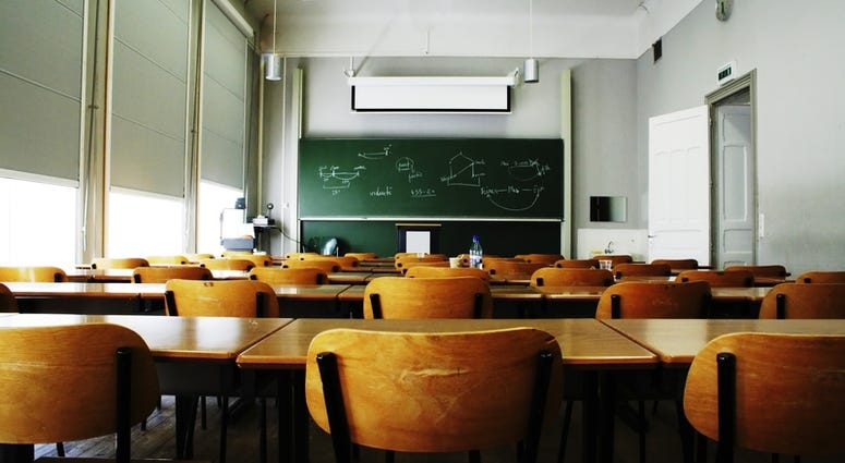 empty classroom A large, empty classroom with wooden chairs.