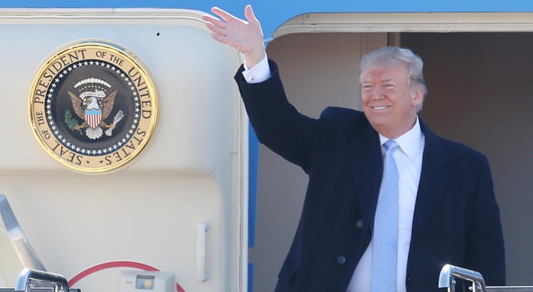 U.S. President Donald Trump waves to the crowds as he exits Air Force One upon his arrival at St. Louis-Lambert International Airport in St. Louis on March 14, 2018. Trump is in St. Louis for a roundtable meeting with Boeing officials and to attend a fund