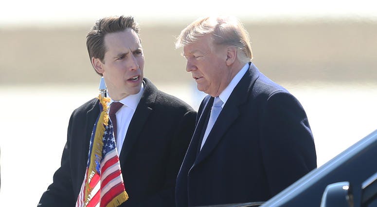 U.S. Senate hopeful, Missouri Attorney General, Josh Hawley talks with U.S. President Donald Trump after the President's arrival at St. Louis-Lambert International Airport in St. Louis on March 14, 2018. Trump is in St. Louis for a roundtable meeting with
