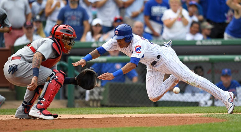 Chicago Cubs shortstop Addison Russell slides safely into home plate against St. Louis Cardinals catcher Yadier Molina Chicago Cubs shortstop Addison Russell slides safely into home plate against St. Louis Cardinals catcher Yadier Molina
