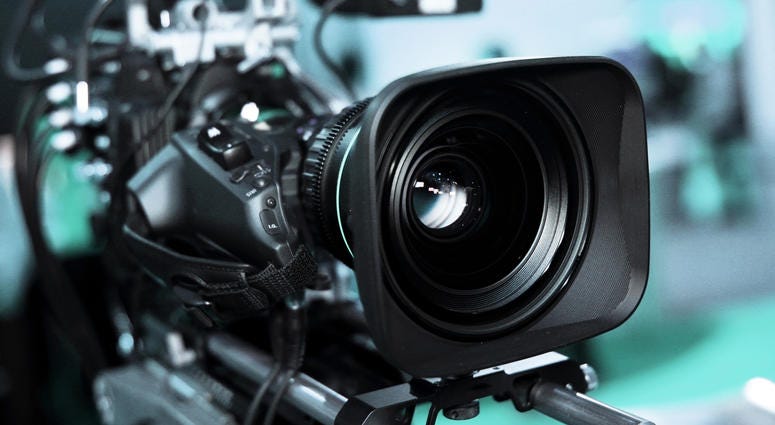 Large professional black video camera filming TV