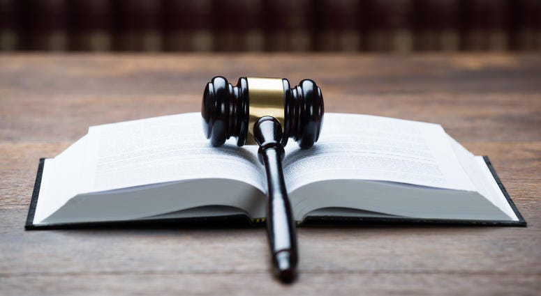 Closeup of mallet on open legal book at table in courtroom